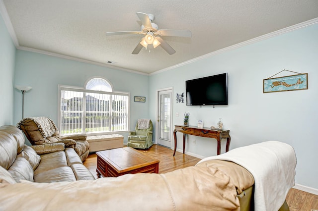 living room featuring ornamental molding, light wood-type flooring, ceiling fan, and a textured ceiling