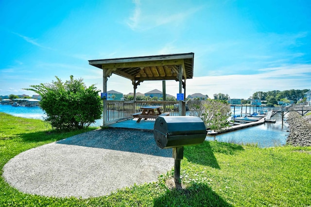 dock area featuring a patio, a gazebo, a yard, and a water view