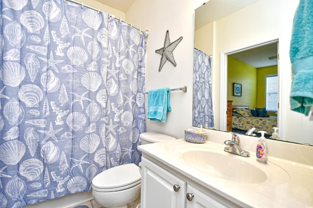 bathroom with walk in shower, vanity, and toilet