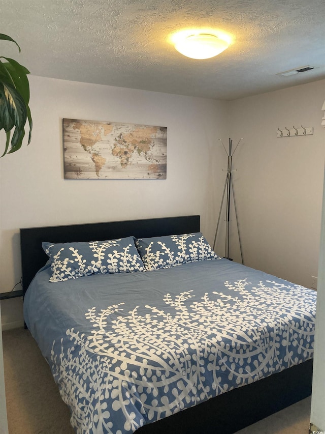 carpeted bedroom featuring a textured ceiling