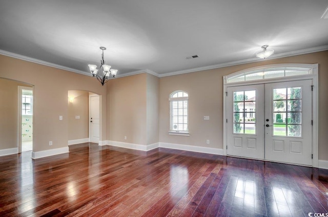 entryway featuring dark wood-type flooring, a notable chandelier, french doors, and ornamental molding