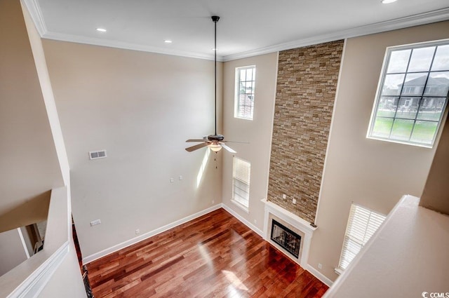 unfurnished living room with a fireplace, ornamental molding, hardwood / wood-style flooring, and ceiling fan