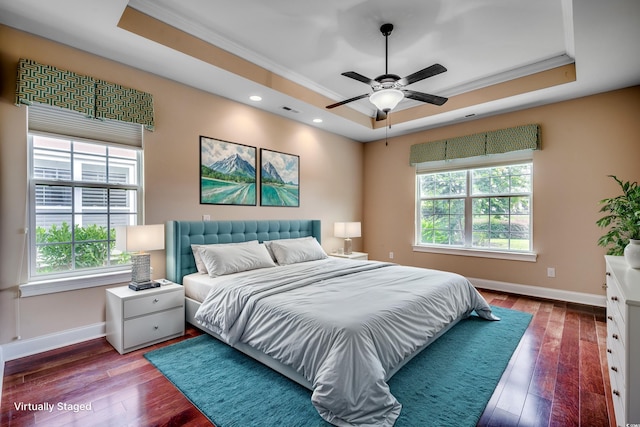 unfurnished room featuring wood-type flooring, a tray ceiling, and a healthy amount of sunlight