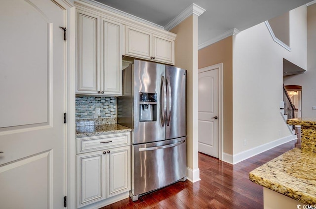 kitchen featuring stainless steel fridge, light stone counters, ornamental molding, and dark hardwood / wood-style flooring