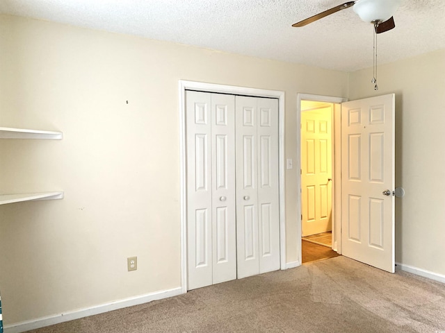 unfurnished bedroom with ceiling fan, a closet, light carpet, and a textured ceiling