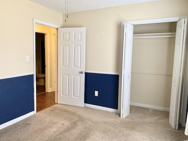 unfurnished bedroom featuring a closet, carpet floors, and a textured ceiling