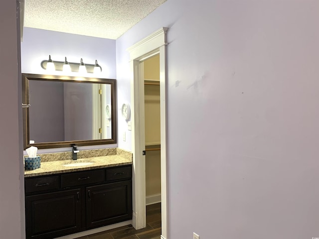 bathroom with vanity, hardwood / wood-style floors, and a textured ceiling