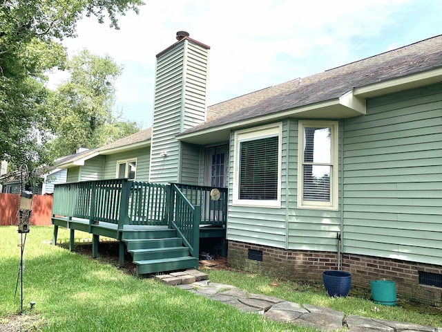 back of house featuring a wooden deck and a lawn