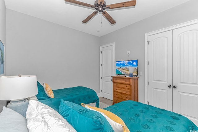 bedroom featuring wood-type flooring, ceiling fan, and a closet