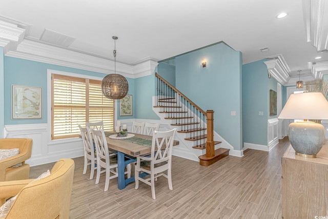 dining area featuring ornamental molding and light hardwood / wood-style floors