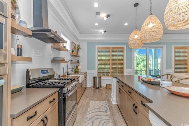 kitchen featuring pendant lighting, sink, ornamental molding, exhaust hood, and stainless steel gas range oven