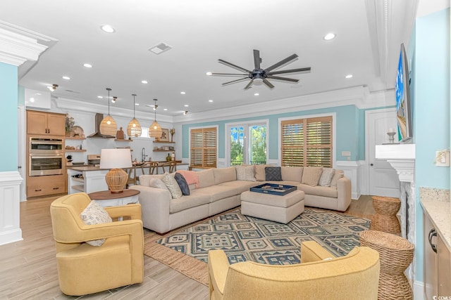 living room featuring ornamental molding, sink, ceiling fan, and light hardwood / wood-style floors