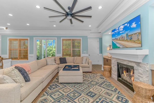 living room with ornamental molding, ceiling fan, and light wood-type flooring