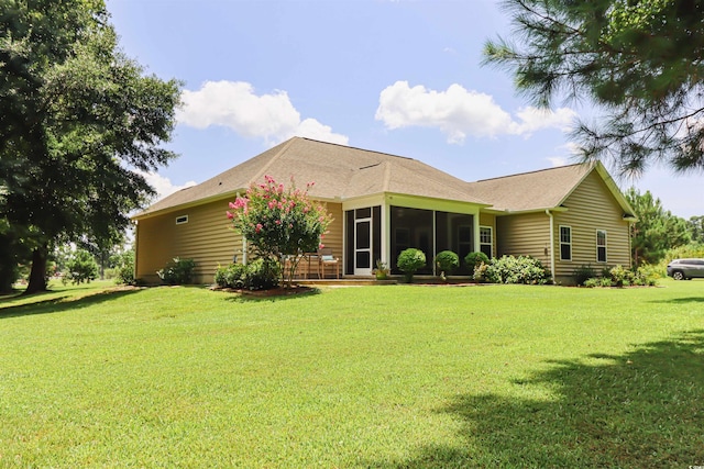 back of house featuring a sunroom and a lawn