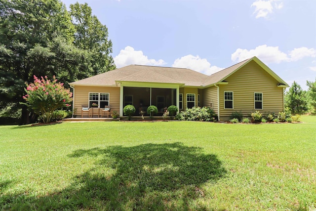 back of property with a sunroom and a yard