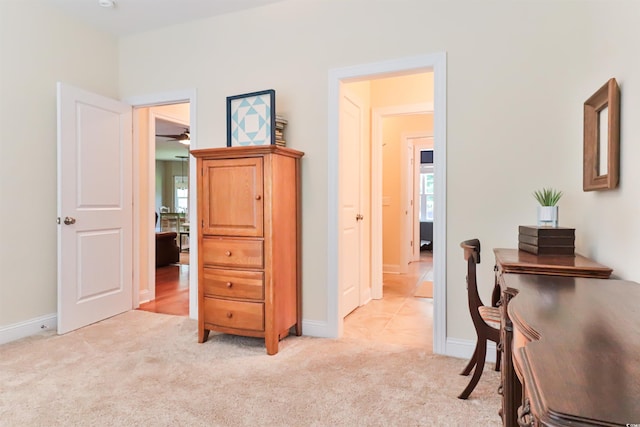 hallway featuring baseboards and light colored carpet