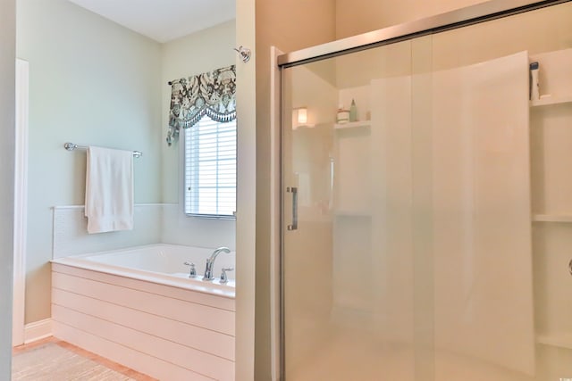 bathroom featuring a shower stall and a bath