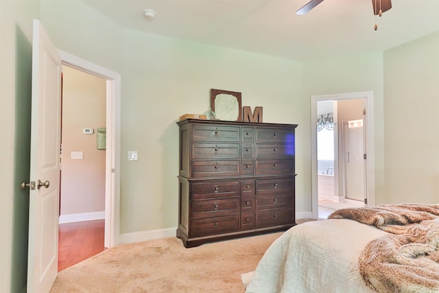 bedroom with carpet floors, connected bathroom, a ceiling fan, and baseboards