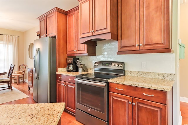 kitchen with stainless steel appliances, backsplash, light wood-style floors, light stone countertops, and baseboards