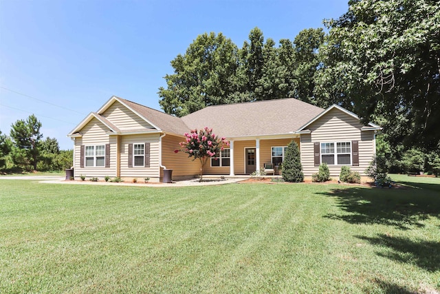 ranch-style house featuring covered porch and a front yard