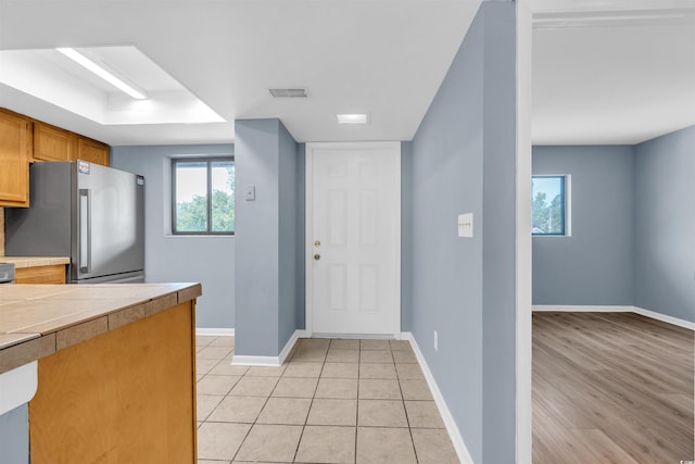 kitchen with stainless steel fridge and light tile patterned floors