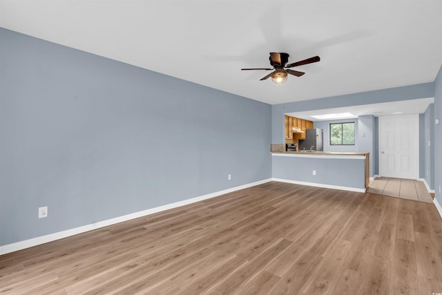 unfurnished living room featuring ceiling fan and light tile patterned floors