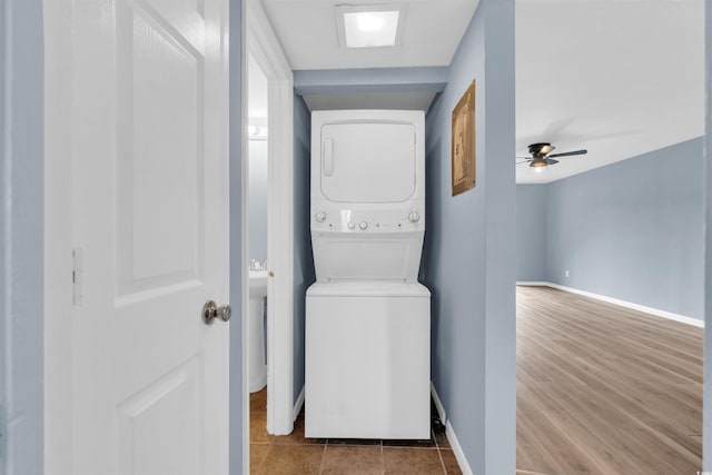 laundry area with stacked washing maching and dryer, ceiling fan, and light wood-type flooring