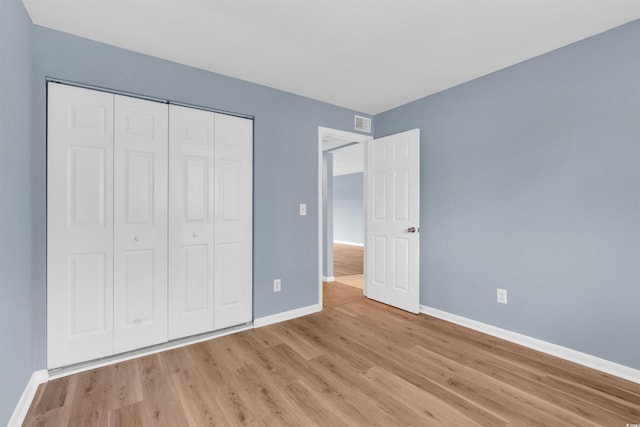 unfurnished bedroom featuring light hardwood / wood-style floors and a closet