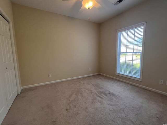 interior space with light carpet, a closet, and ceiling fan