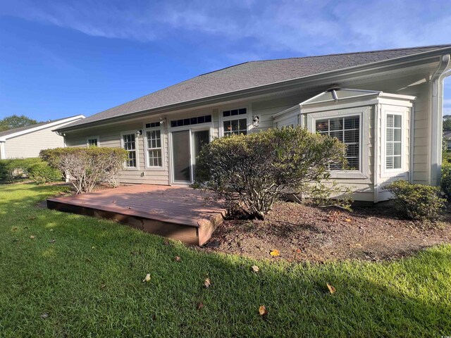 back of house with a deck and a yard