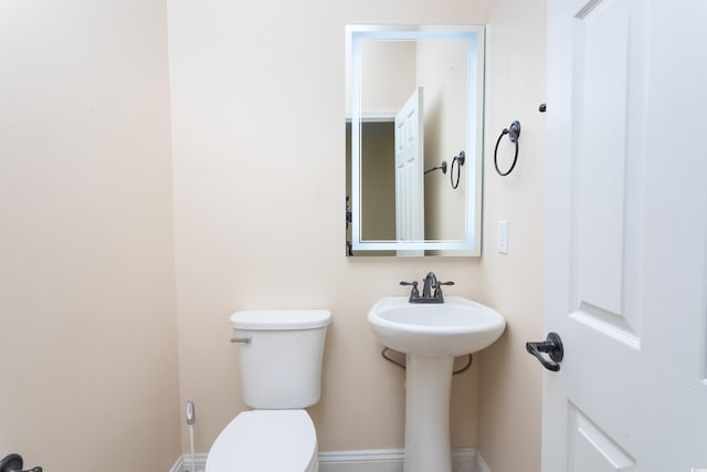 bathroom featuring toilet and baseboards