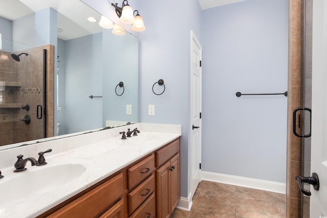 full bath with double vanity, a shower stall, a sink, and tile patterned floors