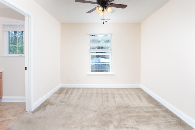 empty room featuring a healthy amount of sunlight, baseboards, and a ceiling fan