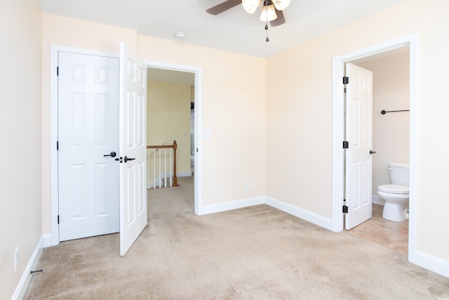 unfurnished bedroom with baseboards, ensuite bath, and light colored carpet