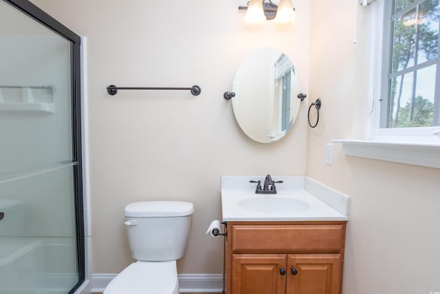 bathroom with a shower with shower door, vanity, and toilet