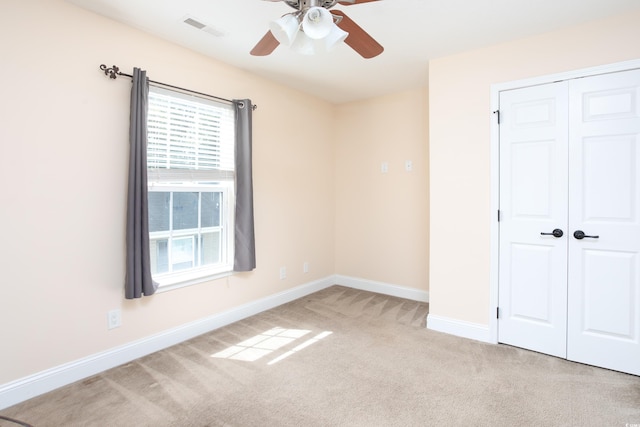 unfurnished bedroom with carpet floors, a ceiling fan, visible vents, baseboards, and a closet