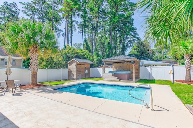 view of swimming pool with an outbuilding, a fenced backyard, a gazebo, a patio area, and a hot tub