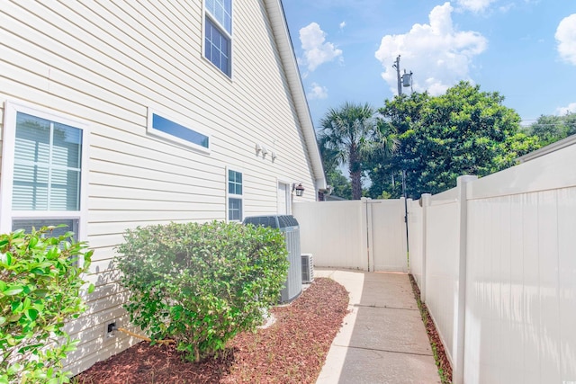 view of side of property with cooling unit and fence