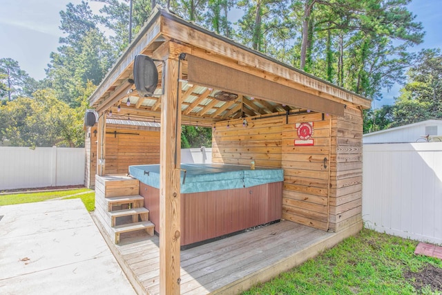 view of patio / terrace with a gazebo, a fenced backyard, and a hot tub