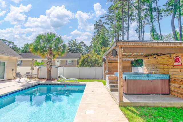 view of pool with a hot tub, fence, a fenced in pool, and a patio