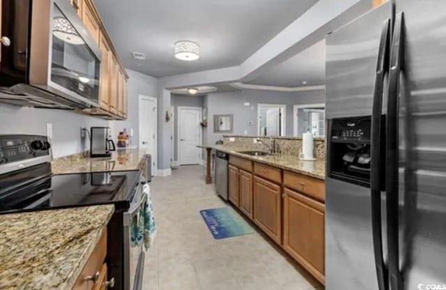 kitchen with light stone counters, ornamental molding, stainless steel appliances, and sink