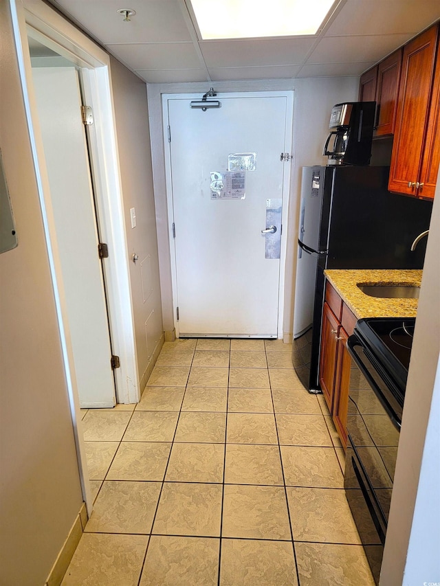 kitchen featuring light tile patterned flooring, black range with electric stovetop, sink, and a drop ceiling