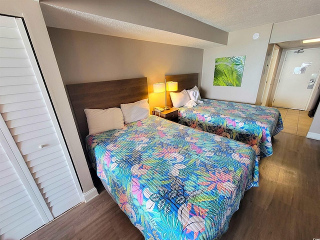 bedroom with dark wood-type flooring and a textured ceiling