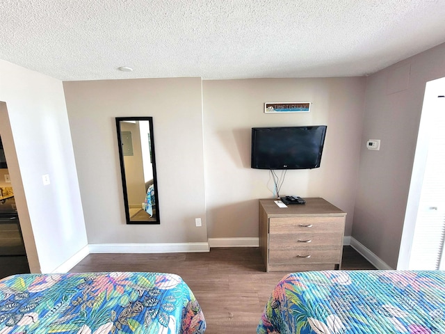 bedroom with dark wood-type flooring and a textured ceiling