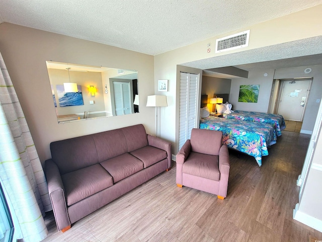 bedroom featuring hardwood / wood-style flooring, a textured ceiling, and a closet