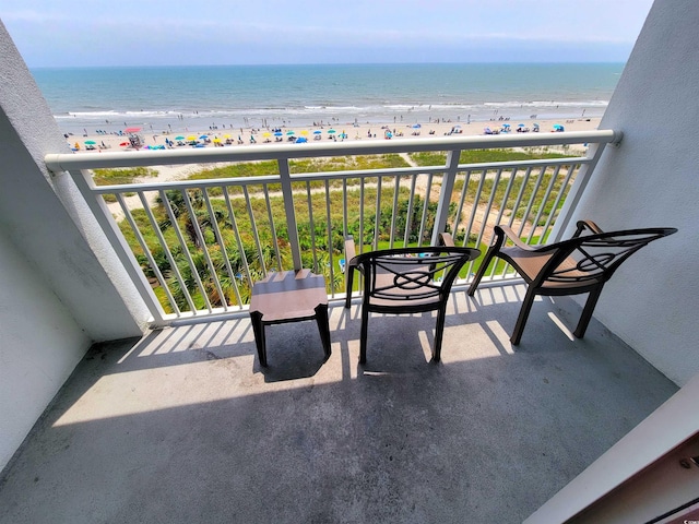 balcony featuring a water view and a beach view