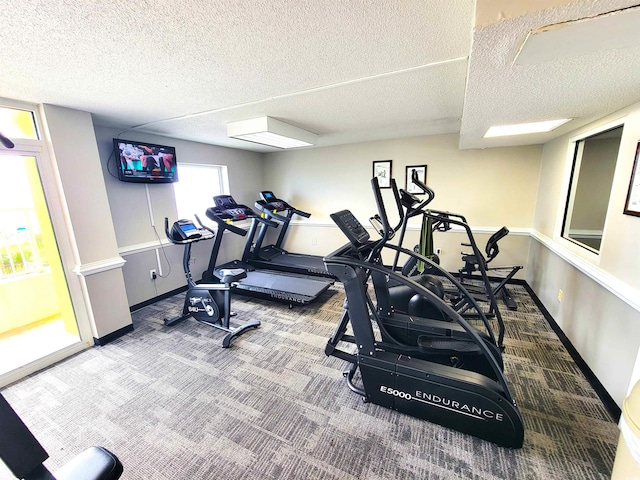 workout area featuring a textured ceiling and carpet