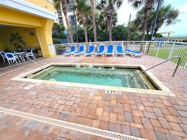 view of swimming pool with a hot tub