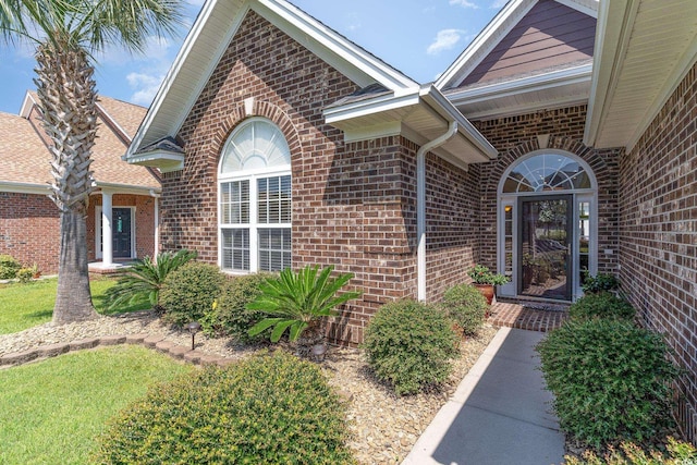 property entrance featuring a lawn