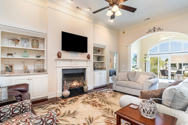 living room with ceiling fan, ornamental molding, dark hardwood / wood-style floors, and built in features